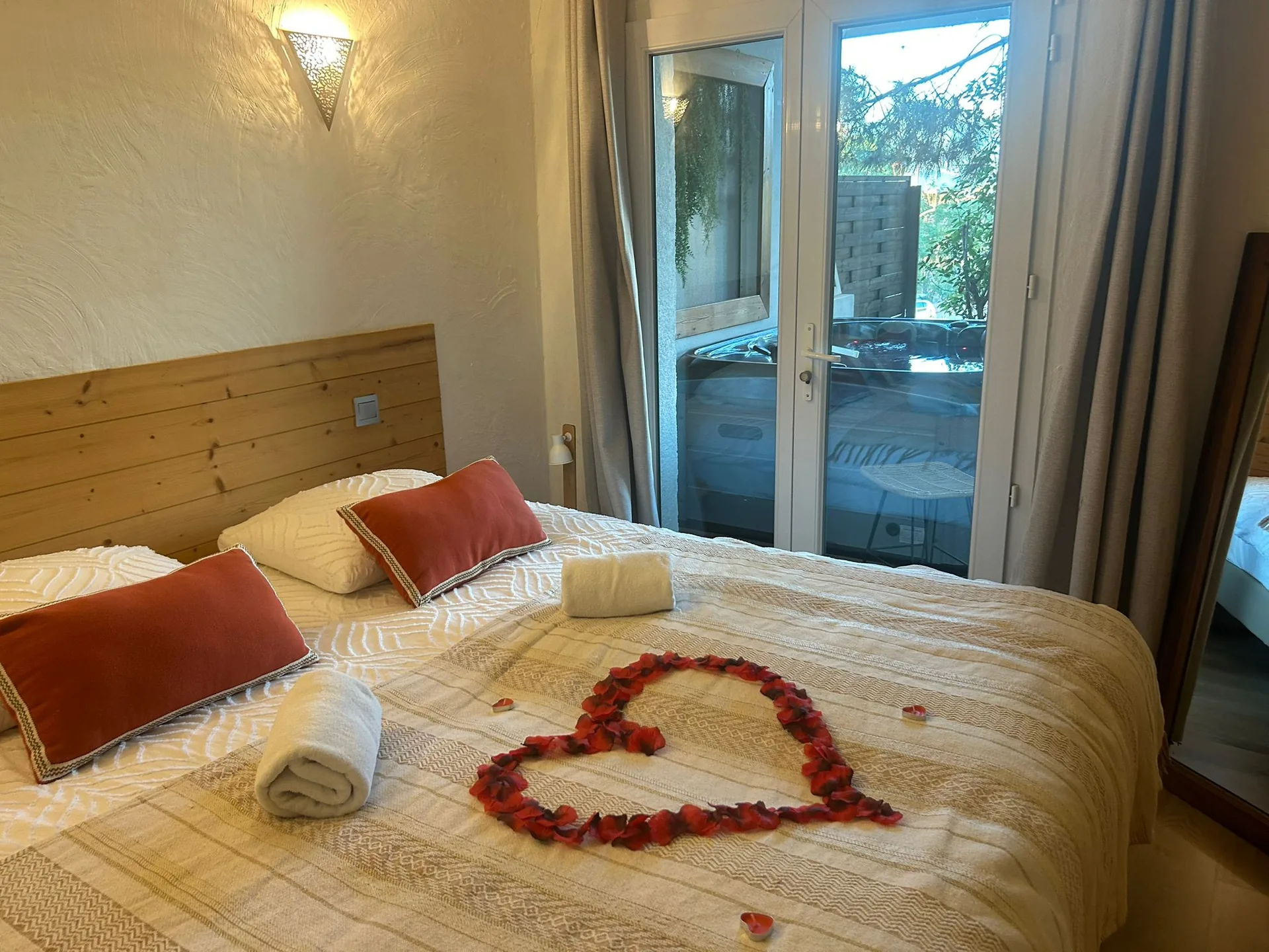 Cama decorada con un corazón de pétalos de rosa